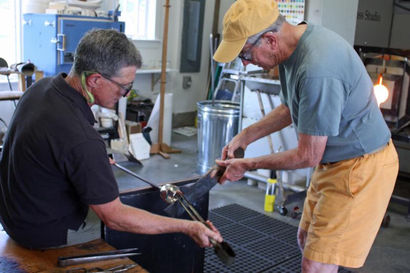 A paddle is used to smooth the top, lip rim, of the drinking glass being made. (Photo by Holly S. Edwards)