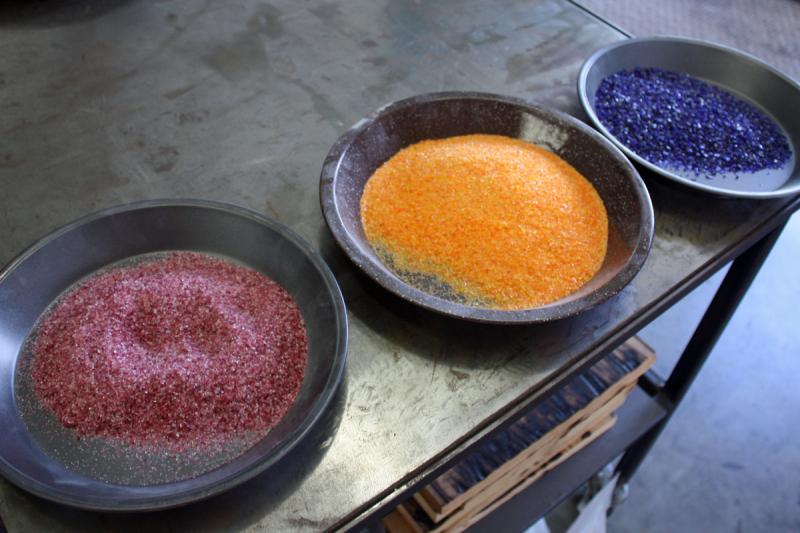 A mixture of silica and fluxes, called frit, is fused at high temperature to make colored glass It is added to molten glass, like sprinkles on a cupcake, heated, blended in and then reheated. (Photo by Holly S. Edwards)
