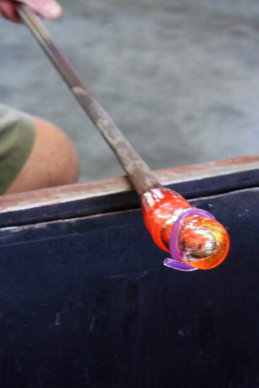 A stainless steel table top, called a marver, is used to roll and shape hot glass between steps in the process. It is also used to blend colored glass that has been adhered to the outside of a blob of clear glass. (Photo by Holly S. Edwards)
