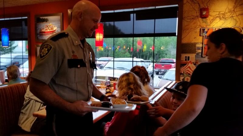 Tim Carroll, Chief Deputy, Knox County Sheriff’s Office, delivers a meal to a table of diners at Applebees. (Photo by Sarah Shepherd)