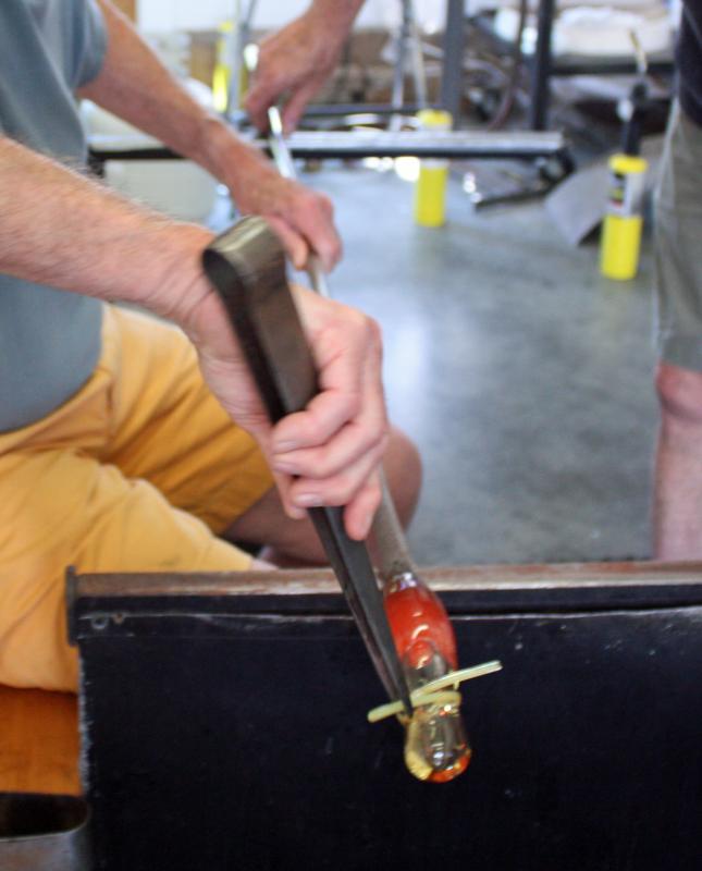 There are only seconds to work and bend the hot glass before the whole thing must be put back into the glory hole and reheated to a pliable state. (Photo by Holly S. Edwards)