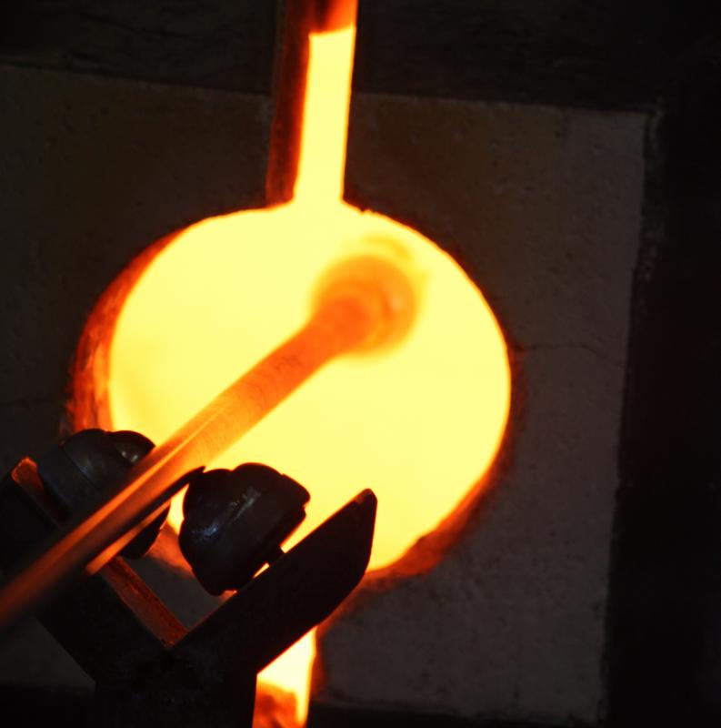 A view of the colored lip wrap inside the glory hole, being reheated so it will become hot enough to create a taffy-like strand around the top edge of the drinking glass. (Photo by Holly S. Edwards)