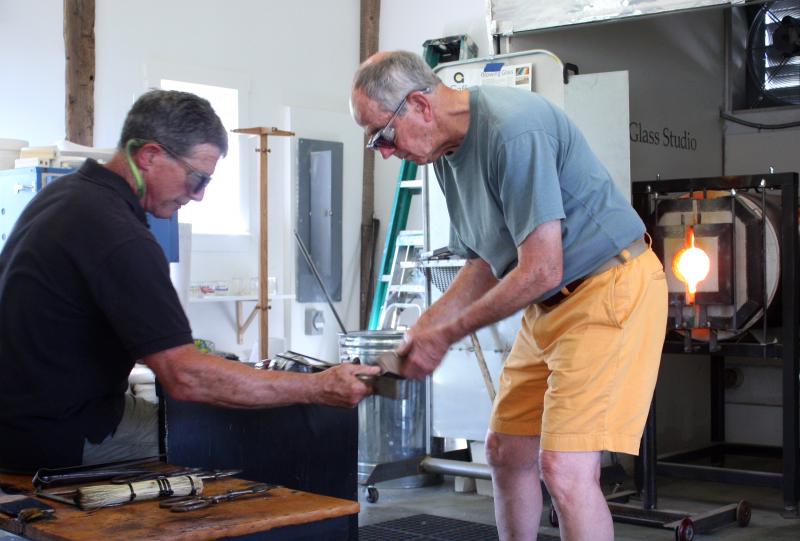 Using a paddle and tweezers to finesse the nearly-completed piece. (Photo by Holly S. Edwards)