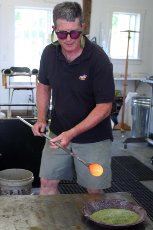 David Jacobson with a glob of molten glass on the end of a blowpipe, getting ready to work with it. (Photo by Holly S. Edwards)