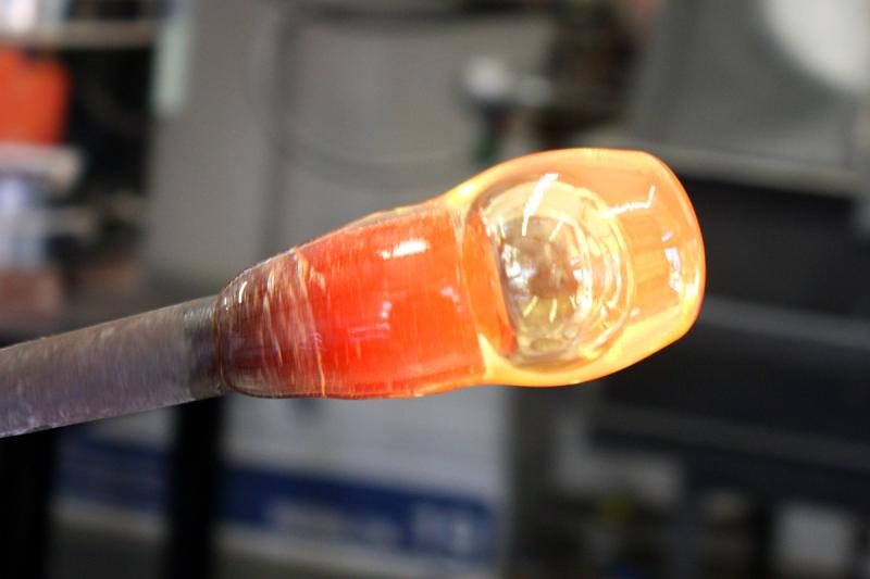 Once the desired cone shape has been achieved and it is centered on the end of the blowpipe, a puff of air sends a bubble into the hot glass, slightly expanding it. (Photo by Holly S. Edwards)