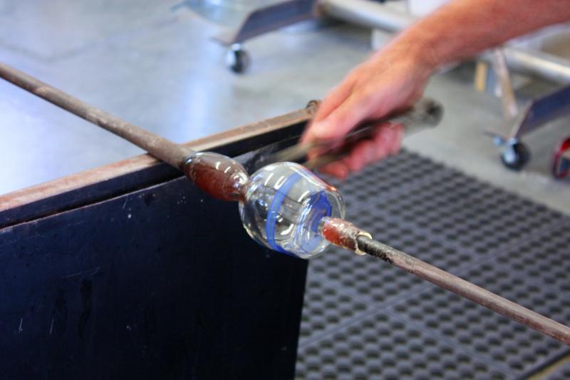 The punty should be just hot enough to attach to the glass and hold it, but not enough to fuse it to the glass so it breaks when it is finished and detached. (Photo by Holly S. Edwards)