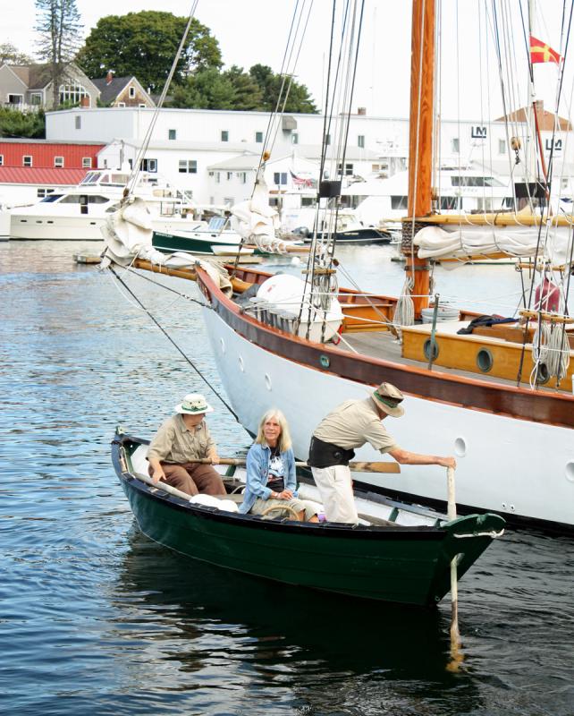 On either end of their dory, Susan and Sam Manning of Camden row Meg Maiden out to the arriving schooners so she can present each with a traditional fresh pineapple welcome. (Photo by Holly S. Edwards)
