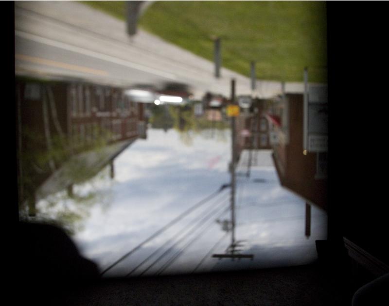 The image from the street reflected from the pinhole aperture and reflected on the back wall.