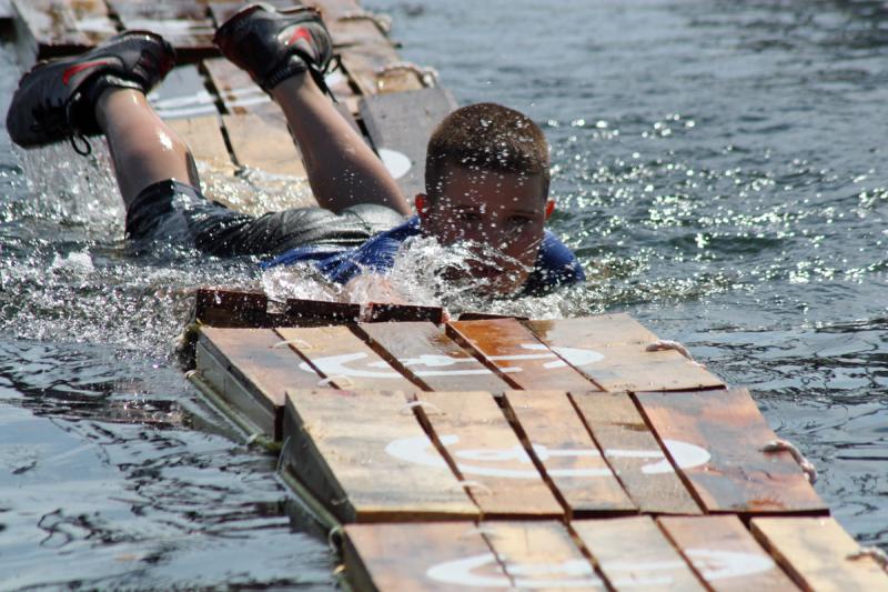Unwilling to give up, this young man worked hard to make his way across the crates in Camden Harbor Saturday, as the crowd enthusiastically cheered him on. (Photo by Holly S. Edwards)