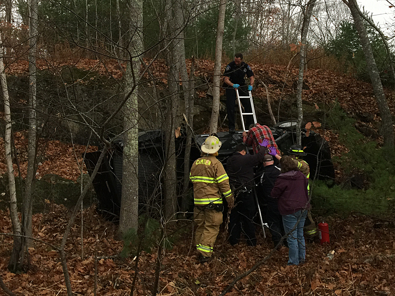 Camden Police Officer Allen Weaver Jr. and members of North East Mobile Health and Camden Fire Department assist Gordon Guist down from his overturned vehicle Nov. 11. (Photo by Holly S. Edwards)