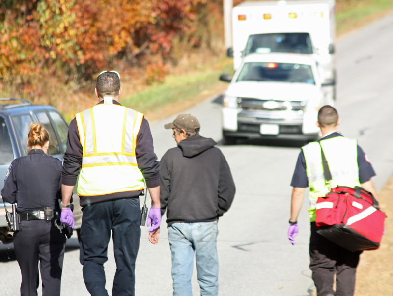 Camden Police Officer Brook Hartshorn and the driver, Kevin Curit, 41, of Lincolnville, walk to a North East Mobile Health ambulance with a pair of emergency medical technicians. (Photo by Holly S. Edwards)