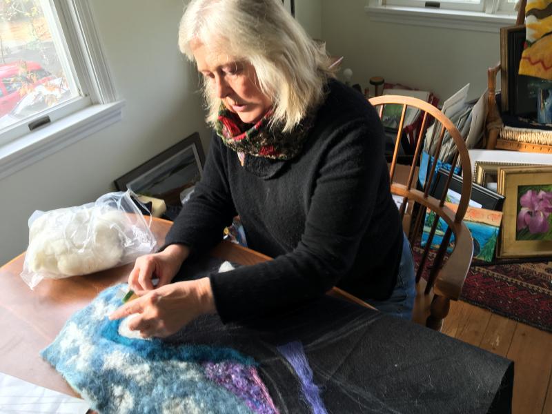 Helen Farnham works her magic on a new piece depicting a breaching whale. SUZI THAYER/Boothbay Register