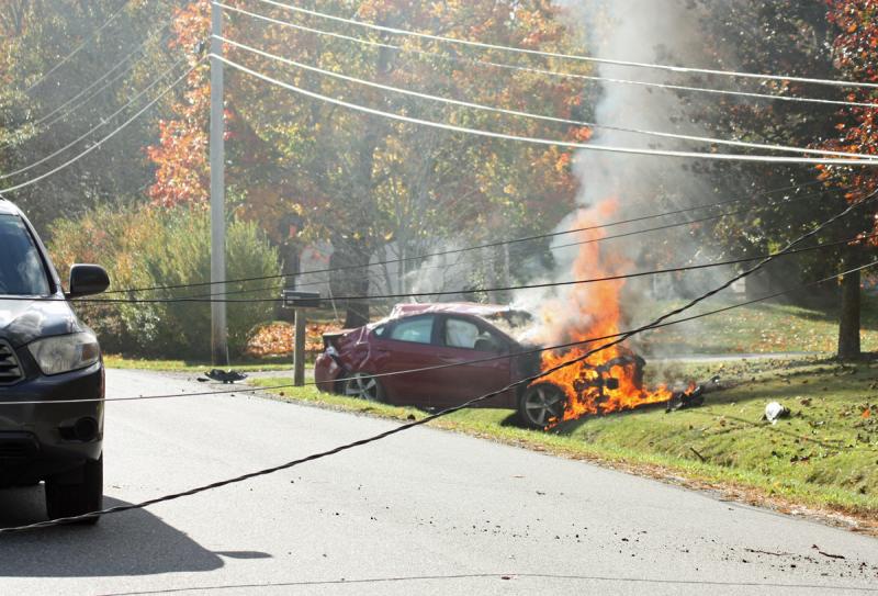 The car to the left of the photo drove under the first pair of near-invisible downed wires, before realizing there was an accident and stopping before she reached the second set and exiting her car. (Photo by Holly S. Edwards)