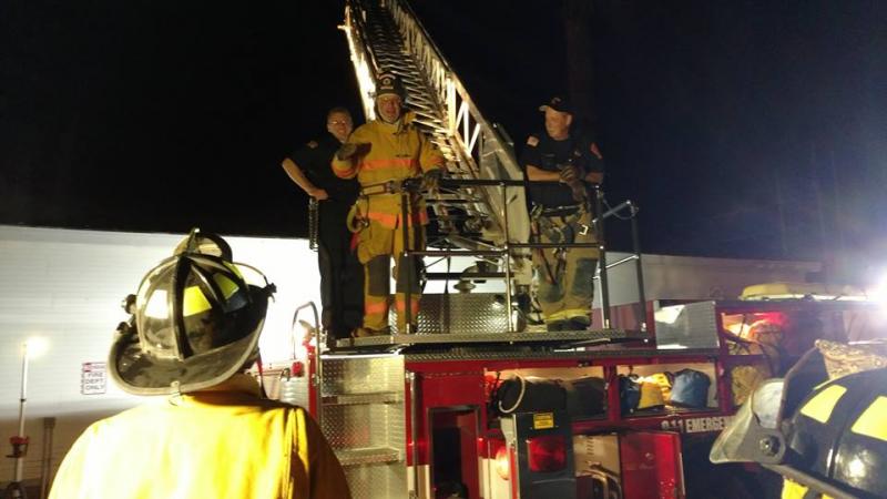 Participants in the inaugural class of the Citizens Public Safety Academy experienced what it was like to climb a 105 foot aerial ladder at night during their first session with the Camden Fire Department. Left to right, Kevin Mulvihill, firefighter, David Heath, student, and Todd Anderson, firefighter. (Photo by Chris Farley)