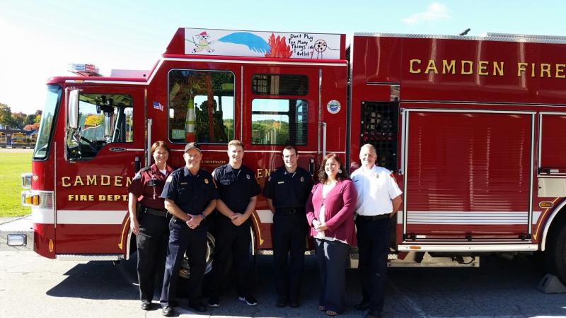 The team of supporters for placing student fire safety messages on the firetrucks include from left, State Fire Investigator Mary MacMaster, Assistant Fire Chief Todd Anderson, firefighters Taylor Benzie and Matt Heath, CRMS Principal Jaime Stone and Camden Fire Chief Chris Farley. (Photo by Sarah Shepherd)