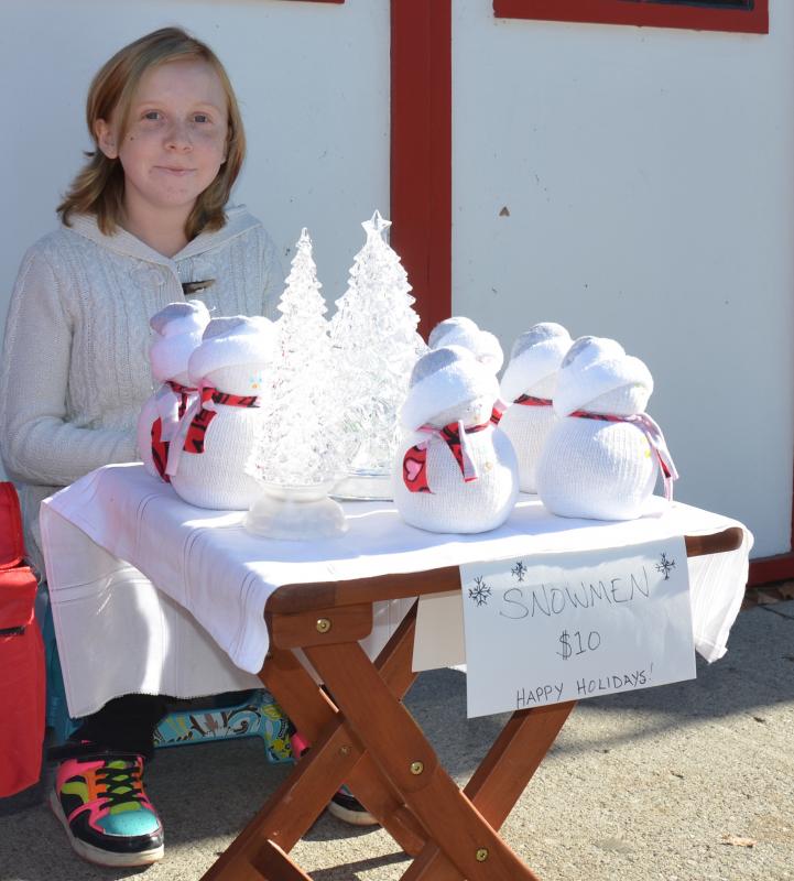 This young girl was selling Christmas decorations on the sidewalk. When asked what she thought about the protest, she said she hoped it would bring more business to her enterprise. (Photo by Lynda Clancy)