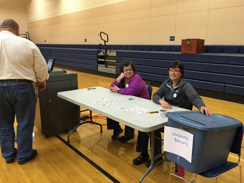 From left, ballot clerks Peggy Rice and Vicki Eugley work the late shift Tuesday evening in Lincolnville, where the Maine Secretary of State’s Office approved using a blue tote as an alternative to collect ballots and speed voting, according to Lincolnville Deputy Warden Karen Secotte. (Photo by Holly S. Edwards)