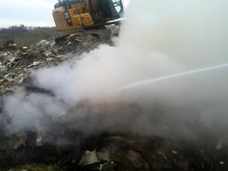 A Sargent excavator helps pull apart the burning pile so firefighters can douse it with water. (Courtesy Rockport Fire Dept.)