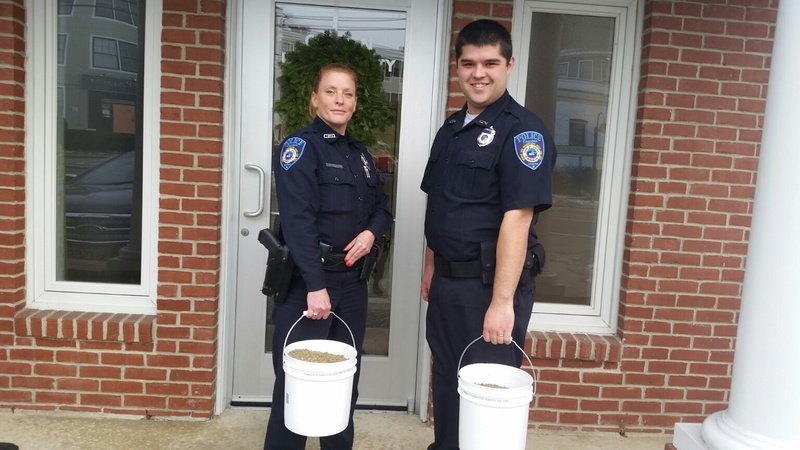 Camden Patrol Officer Brook Hartshorn and Parking Enforcement Officer Mark Bennett hold full buckets of sand ready to be delivered to homes of participants in the Sand for Seniors program. (Photo by Sarah Shepherd)
