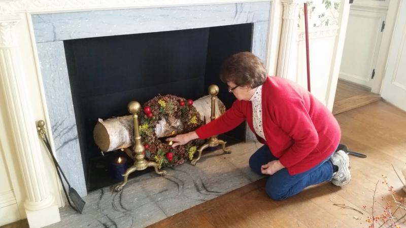 Joanne Richards, Lady Knox DAR Chapter, puts the finishing touches on a fireplace display in the dining room. (Photo by Sarah Shepherd)