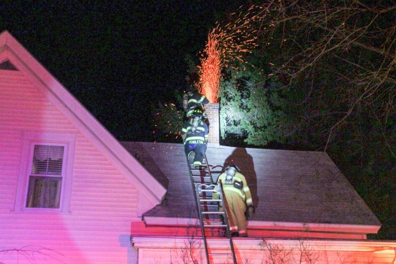 Sparks fly out from the top of a chimney at a home on Suffolk Street in Rockland Saturday night. (Courtesy Rockland Fire Department/by Alan Athean)