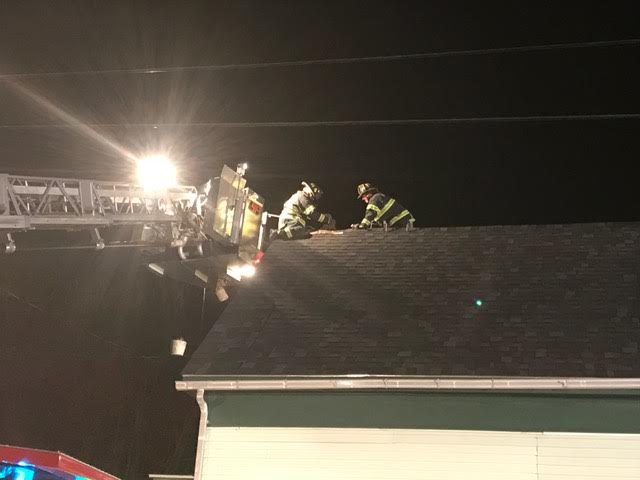 Dec. 31, 2016, Trinity Street. One Rockland firefighter works while tethered to a fire truck ladder. The other firefighter works from a suspension ladder. (Photo by Alan Athearn)