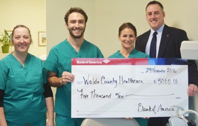 Brian King (far right), site executive for Bank of America presents a check for $5,000 from the Bank of America Charitable Foundation to representatives from Waldo County Dental Care. From left to right: Brenda Reed, dental assistant; Enrico Ross, a dental student from the University of New England who has interned with Waldo County Dental Care; Mandie Hood, dental assistant.