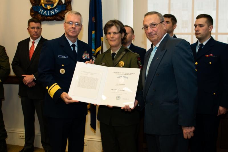 Gov. Paul R. LePage and Rear Adm. Steve Poulin award Specialist Corrie Roberts the Silver Lifesaving Medal at the Maine State House in Augusta on Tuesday, March 28, 2017. Roberts was recognized for her actions during a search and rescue case in October 2015 when she jumped onto a moving lobster boat to assist an unresponsive fisherman. (U.S. Coast Guard photo by Petty Officer 3rd Class Andrew Barresi)