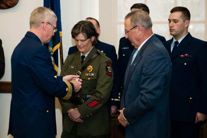 Gov. Paul R. LePage and Rear Adm. Steve Poulin award Specialist Corrie Roberts the Silver Lifesaving Medal at the Maine State House in Augusta on Tuesday, March 28, 2017. Roberts was recognized for her actions during a search and rescue case in October 2015 when she jumped onto a moving lobster boat to assist an unresponsive fisherman. (U.S. Coast Guard photo by Petty Officer 3rd Class Andrew Barresi)