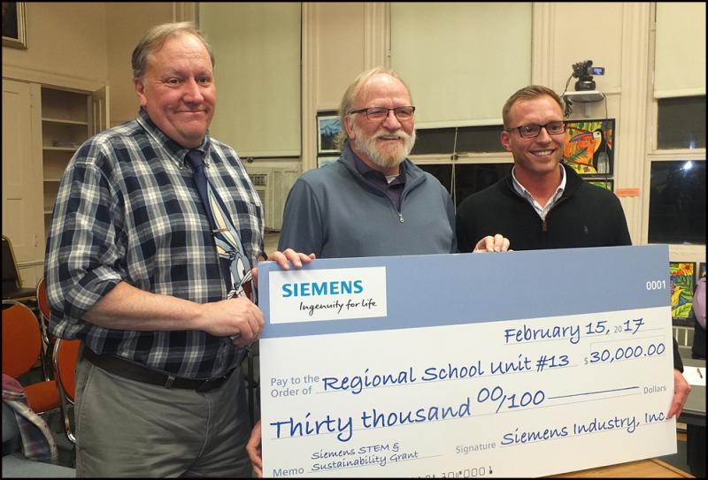 RSU 13 Superintendent John McDonald, Board Chair Steve Roberts and Tom Seekins of Siemens Industry Inc. Seekins is presenting a check for $30,000 to the RSU 13 school system. (Photos by Chris Wolf)