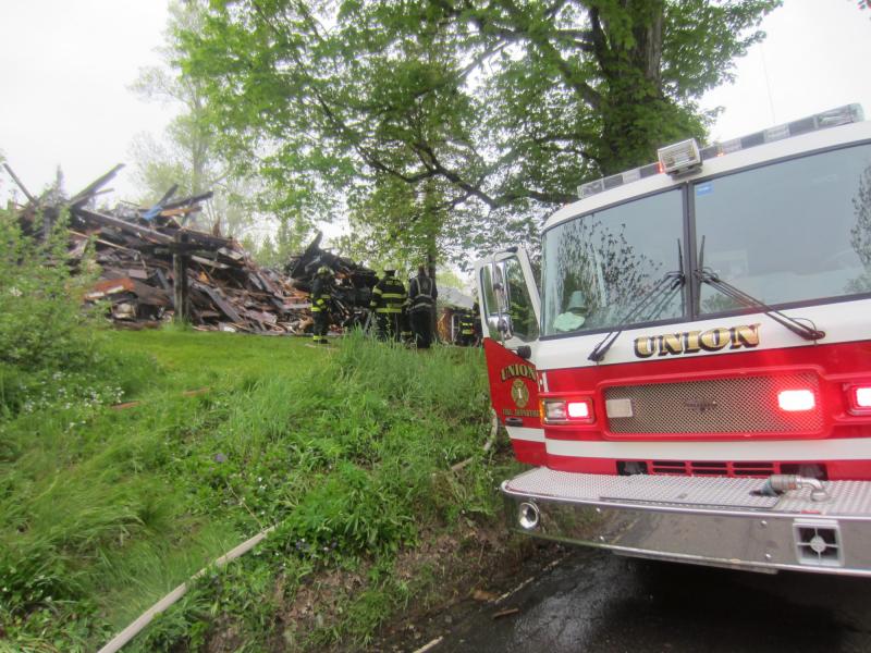 An excavator eventually had to be brought in to the fire scene to level the remaining structure so firefighters could pour water onto the stubborn embers. (Maine Fire Marshal’s Office)