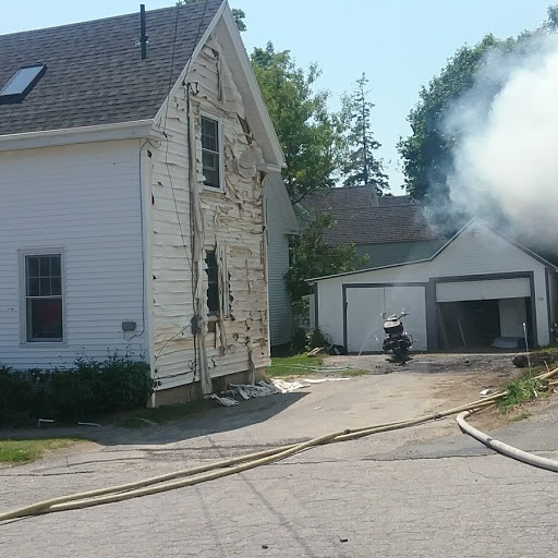 The owner of this motorcycle wasn’t able to move it due to the fire’s intense heat. Instead, he aimed his garden hose at it. (Photo by Matthew Snow)