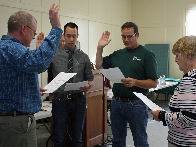 From left, Lincolnville Town Administrator David Kinney administers the oath of office to Josh Gerritsen, a new member of the Board of Selectmen; and Budget Committee members Garry Schwall and Dorothy Lanphere at the annual Town Meeting June 15. (Not present: Jonathan Fishman, Jill Feeney, Rebecca Stephens and Ed O’brien.) (Photo by Holly S. Edwards)