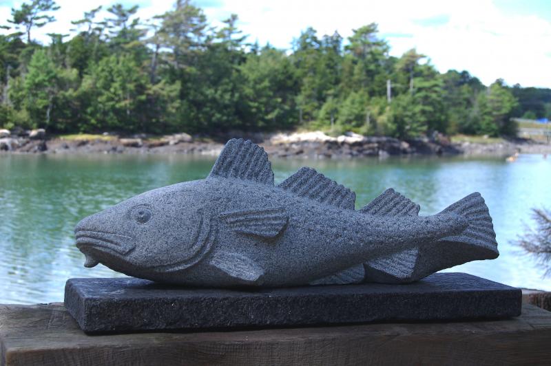 Lindsay’s scultpture “COD,” on permanent display at the Portland Jetport made from St. George granite, about 30” long. (Shown here at Maine Coastal Botanical Gardens).