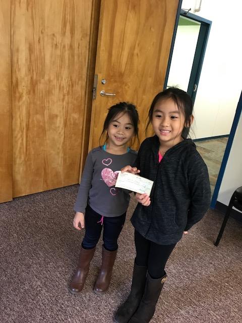 Kaidi (left) and Kaida Kguyen present a check for $675, proceeds from their recent fundraiser, to MCH Meals on Wheels in Rockland. (Photo courtesy of Tracie Nguyen)
