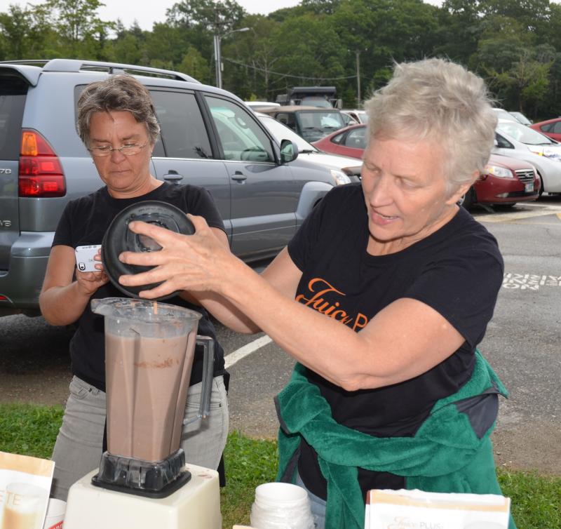 Venita Robinson, owner of Nature’s Choice in Camden, and Kate Mcmorrow make protein drinks for swimmers and paddlers.