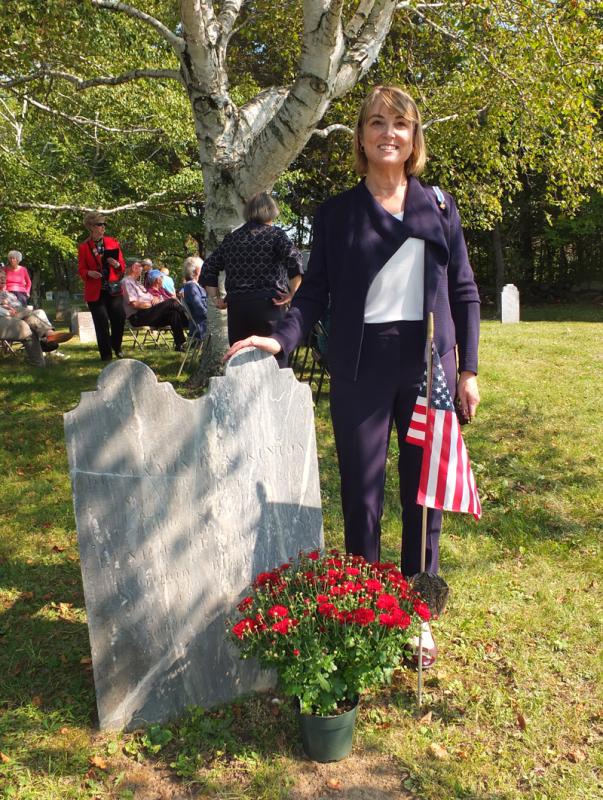 Kate Marshal stands beside here family’s restored headstone.