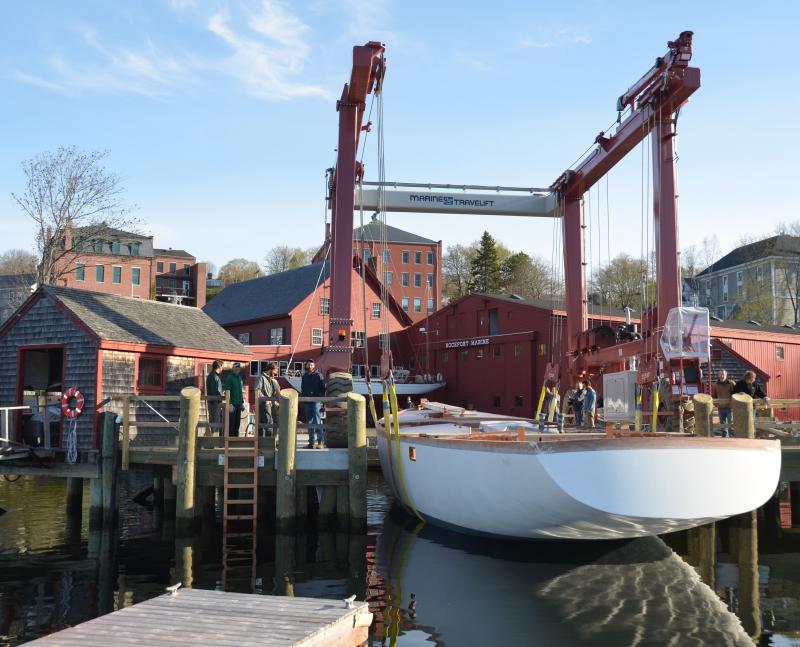 The hull is gently lowered into the water for the first time ever, before being towed over to Brooklin, across the bay and down Eggemoggin Reach. (Photo by Lynda Clancy)