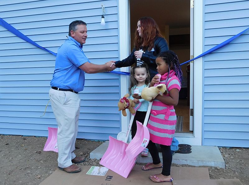 Senator Mike Thibodeau gives the family shovels for the fast approaching winter. (photo by Erica Thoms)