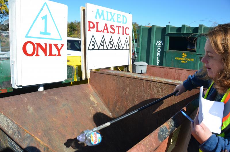 Beth Kwiatkowski mans the front desk at the Midcoast Solid Waste Transfer Station in Rockport, and holds up a No. 1 plastic container. This plastic will get baled and shipped to southern Maine to enter the recycling market. (Photo by Lynda Clancy)