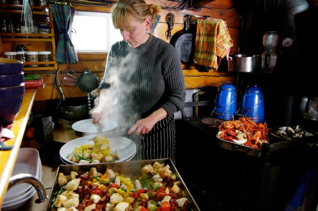 Chef Annie Mahle in the galley of the schooner J. & E. Riggin, prepping a dish. (Photo courtesy Greg Roscoe)