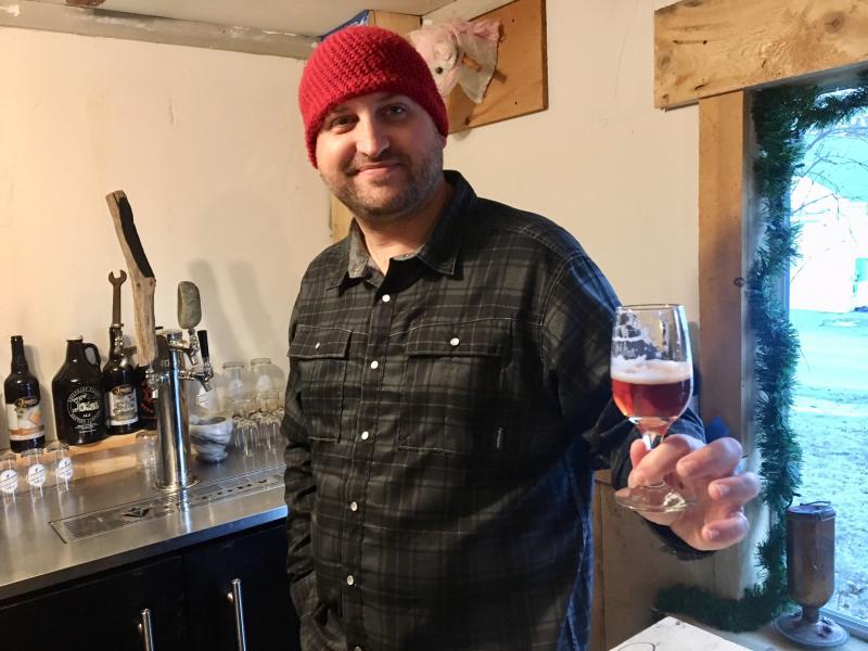 Nick Ullo with one of the beers he and Dan Pangburn have brewed. SUZI THAYER/Boothbay Register