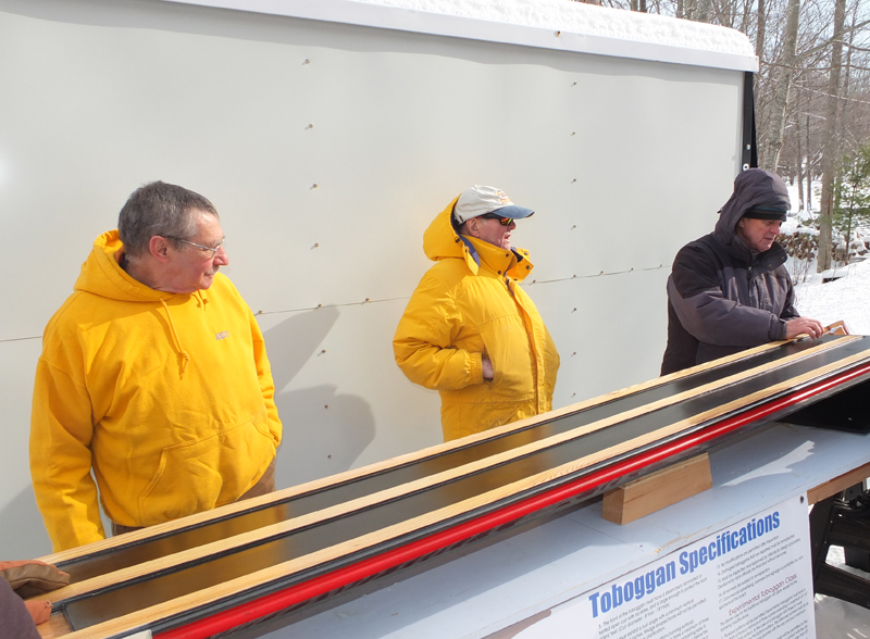 Andy Hazen, Bob Annis and Don Abbott inspect the toboggans