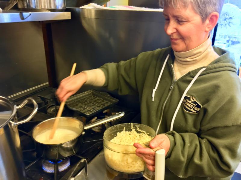 Kim Martin works her magic over a pot of cheese fondue in the kitchen at Eventide. SUZI THAYER/Boothbay Register