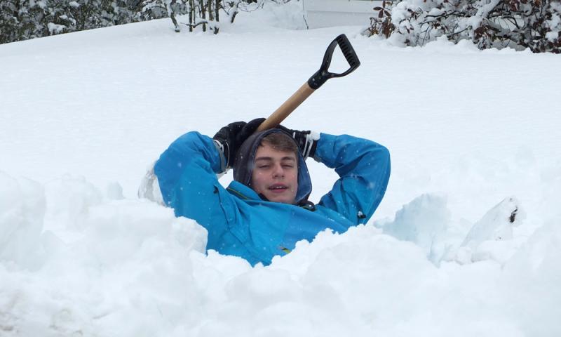 Aidan Schecter takes a break from shoveling. (Photo by Chris Wolf)