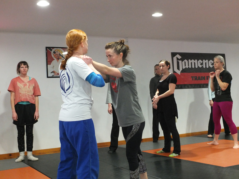 Angela Crawford and Erin Scalli demonstrate a defensive move.