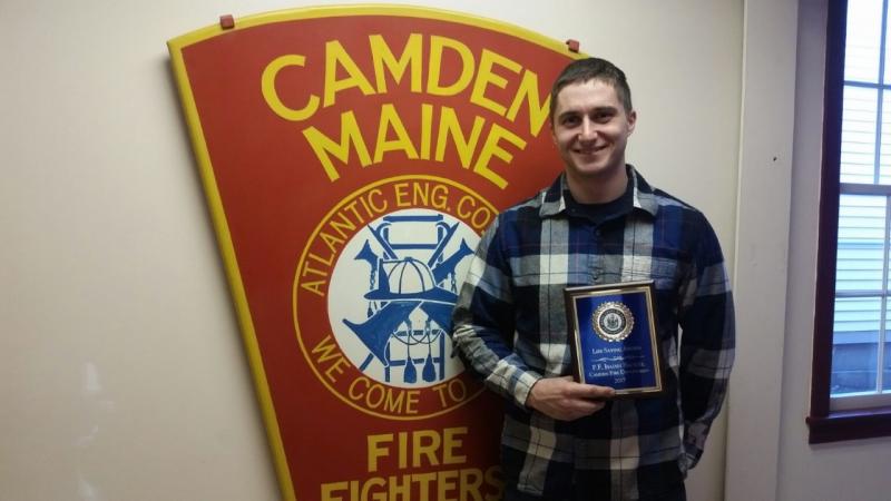 Isaiah Backiel, Camden firefighter, stands with this Life Saving Award from the Maine Chiefs of Police Association. (Photo by Sarah Shepherd)