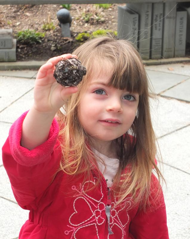 One of the kids displays the seed-ball she made.