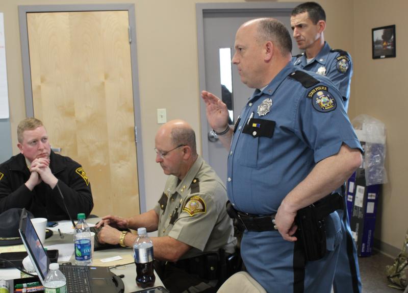Lt. Brooks, Sheriff Lancaster, Lt. Col Cote and Penobscot Sheriff Troy Morton at the command post, inside the fire station. (Photo courtesy Maine Office of Public Safety)