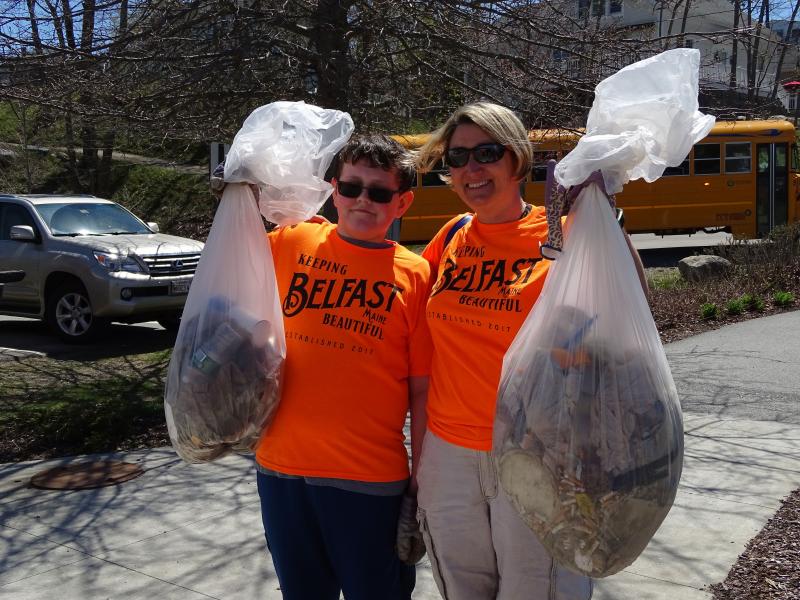 Martha Conway-Cole stands beside a student with some of the trash they picked up. (photo by Erica Thoms)